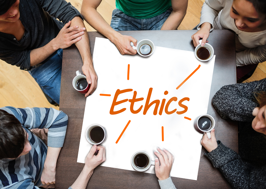 Team brainstorming over a poster on a table with ethics written